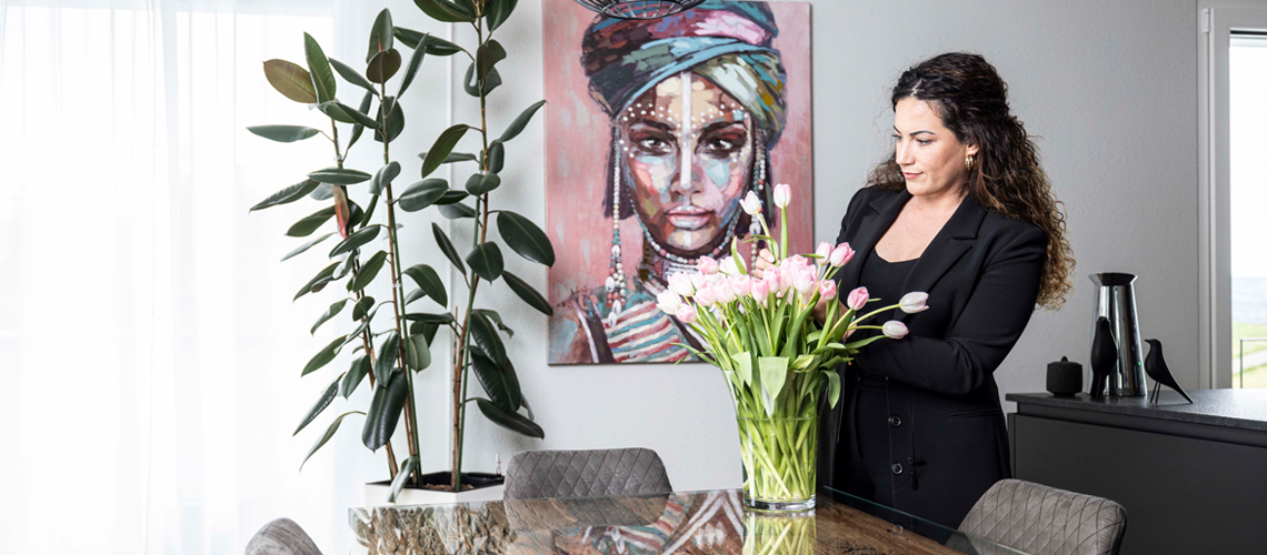 Frau mit Blumen in moderner Wohnung