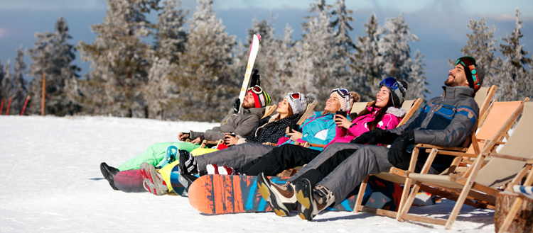 Freunde sonnen sich im Skigebiet